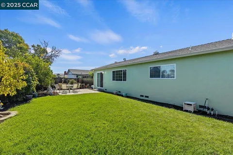 a view of a house with backyard and sitting area