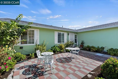 a view of a patio with table and chairs potted plants and wooden fence
