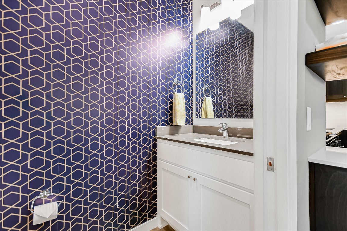 2414 East Martin Luther King Jr Boulevard, Unit A Austin, TX 78722 - Photo 18 of 32 a bathroom with a granite countertop sink and a mirror