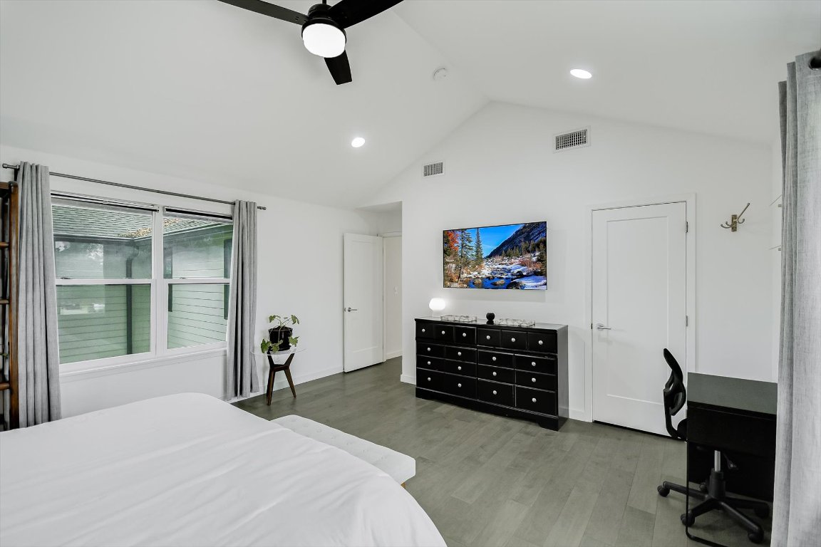 2414 East Martin Luther King Jr Boulevard, Unit A Austin, TX 78722 - Photo 22 of 32 a bedroom with a bed and a flat tv screen