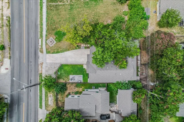 an aerial view of residential houses with outdoor space and trees
