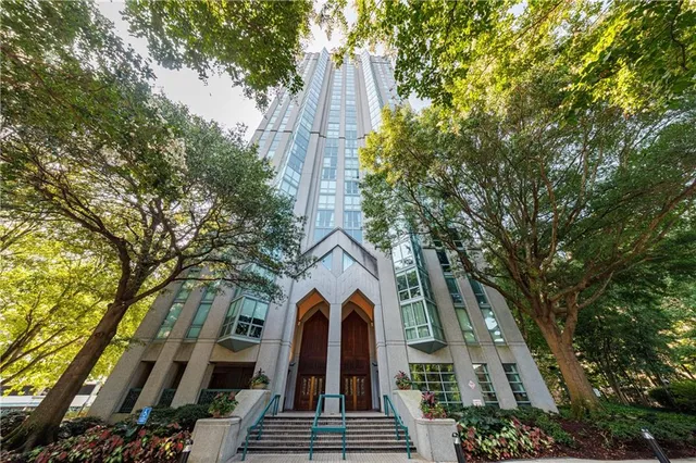 a view of a brick building next to a large tree