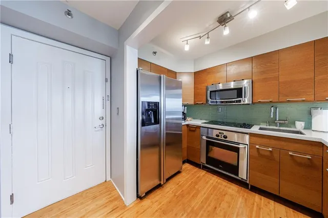 a kitchen with stainless steel appliances granite countertop a refrigerator and a stove top oven