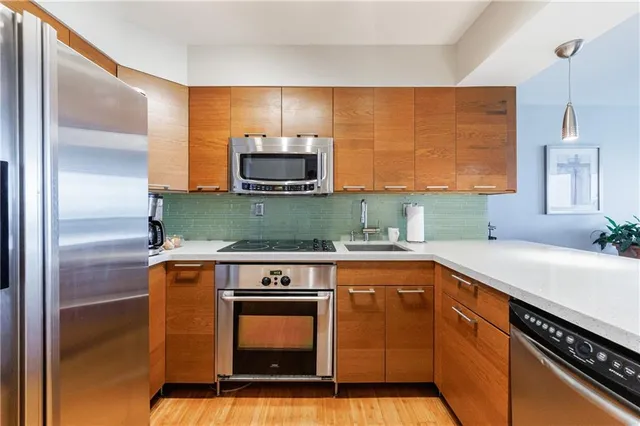 a kitchen with stainless steel appliances a sink stove and refrigerator