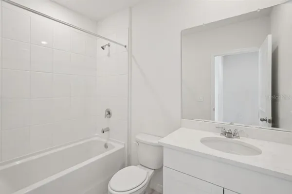 a bathroom with a toilet a sink a mirror a bathtub and shower