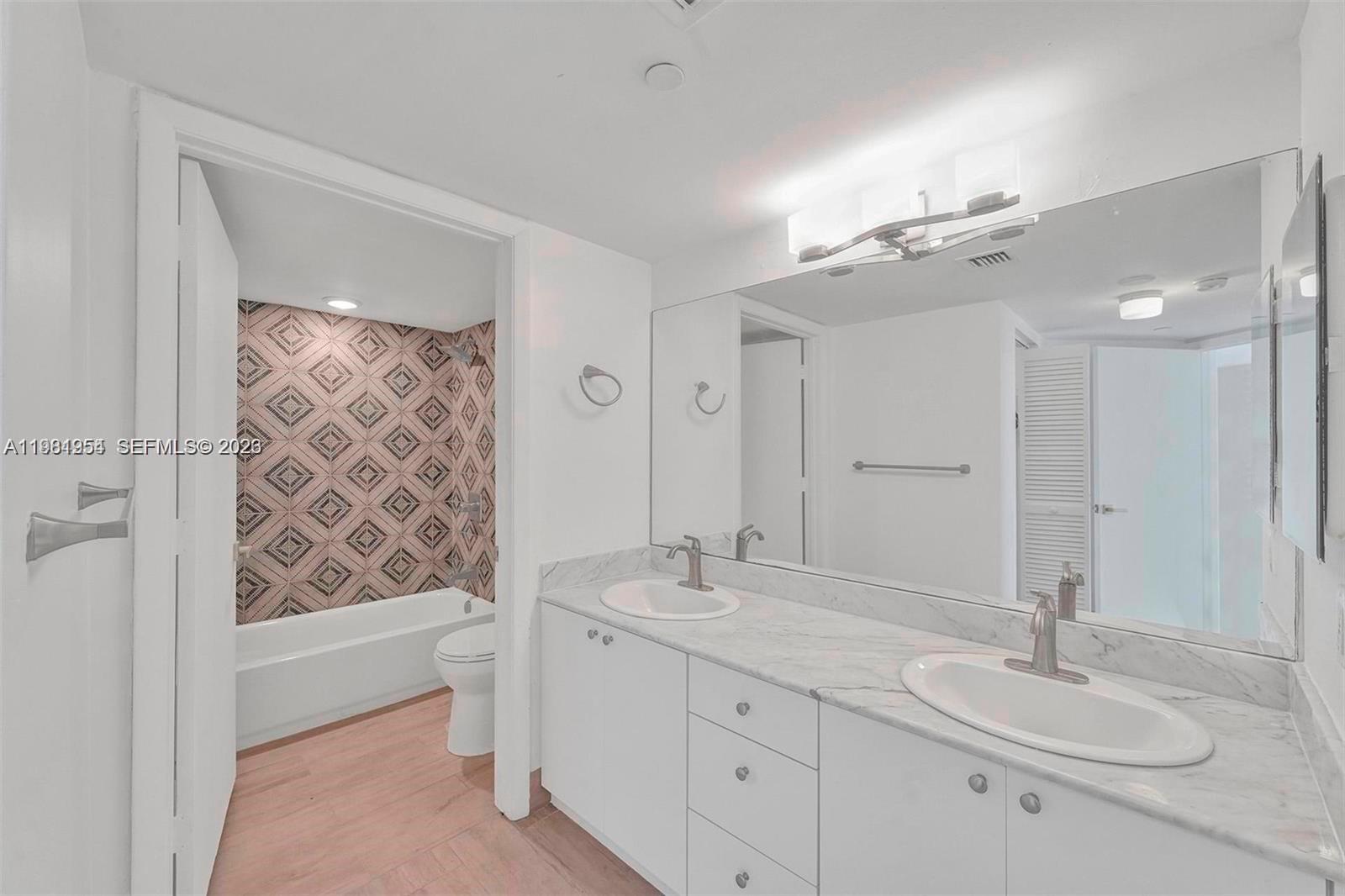 8911 Collins Avenue, Unit 703 Surfside, FL 33154 - Photo 16 of 24 a bathroom with a double vanity sink mirror and shower