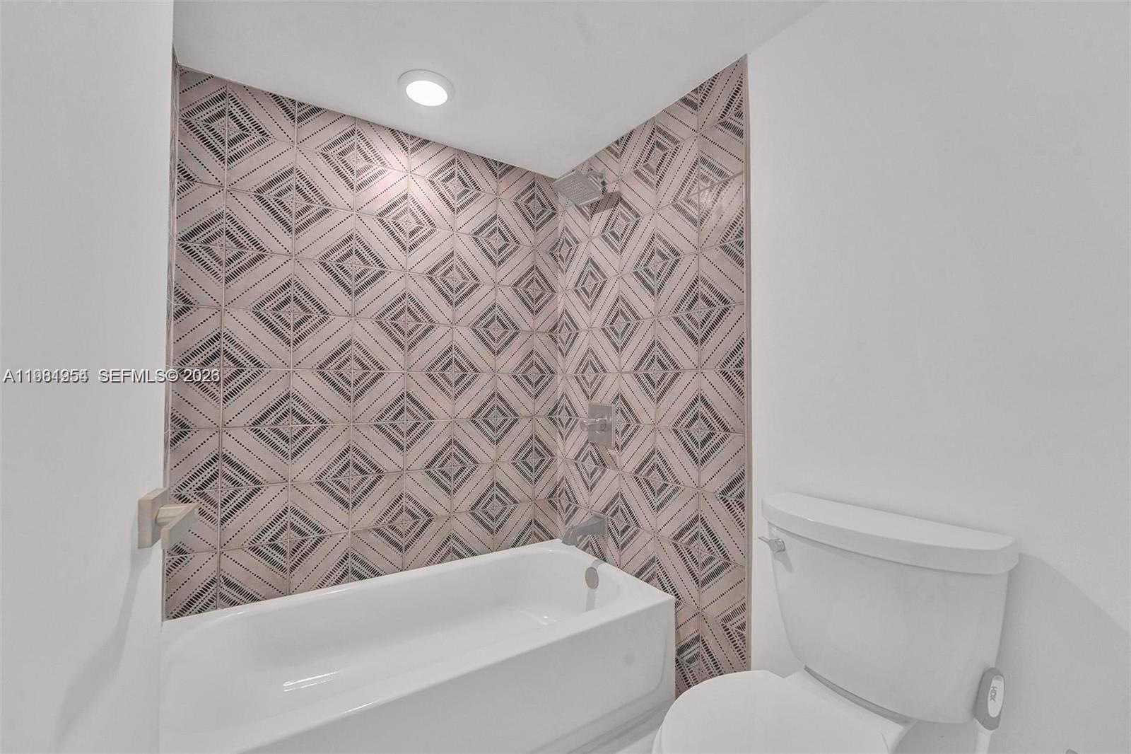 8911 Collins Avenue, Unit 703 Surfside, FL 33154 - Photo 17 of 24 a bathroom with a toilet and a shower curtain