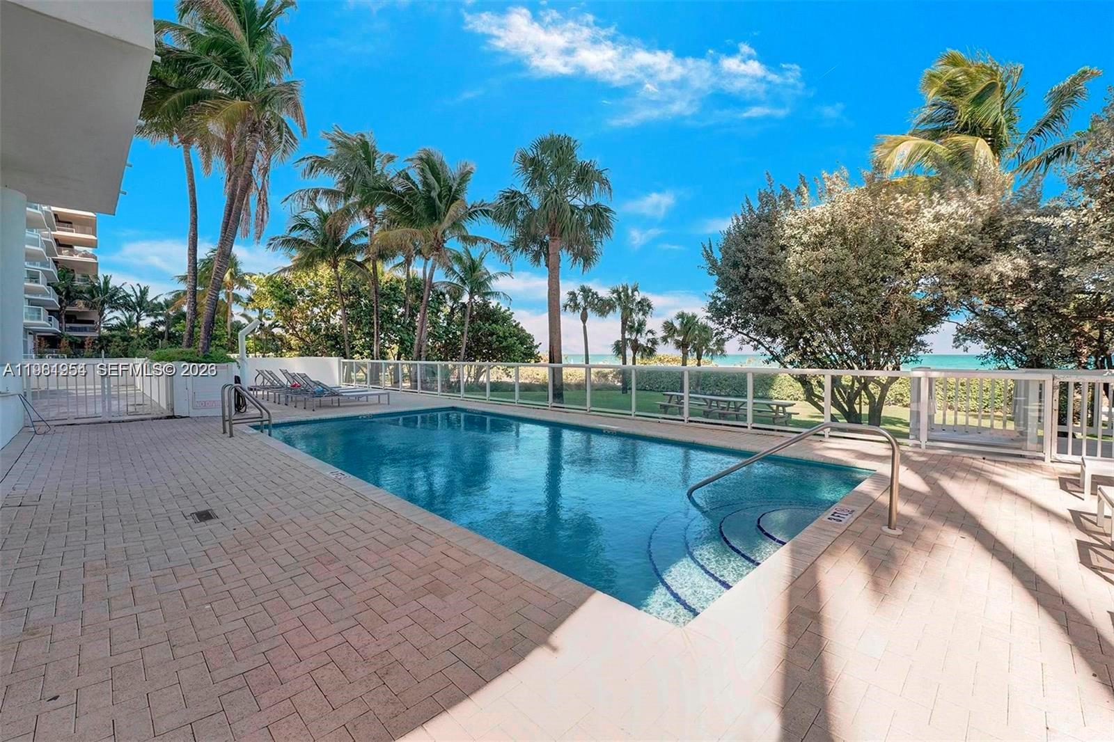 8911 Collins Avenue, Unit 703 Surfside, FL 33154 - Photo 19 of 24 a view of a swimming pool with an outdoor seating