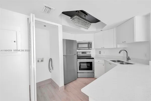 a kitchen with stainless steel appliances a refrigerator sink and cabinets