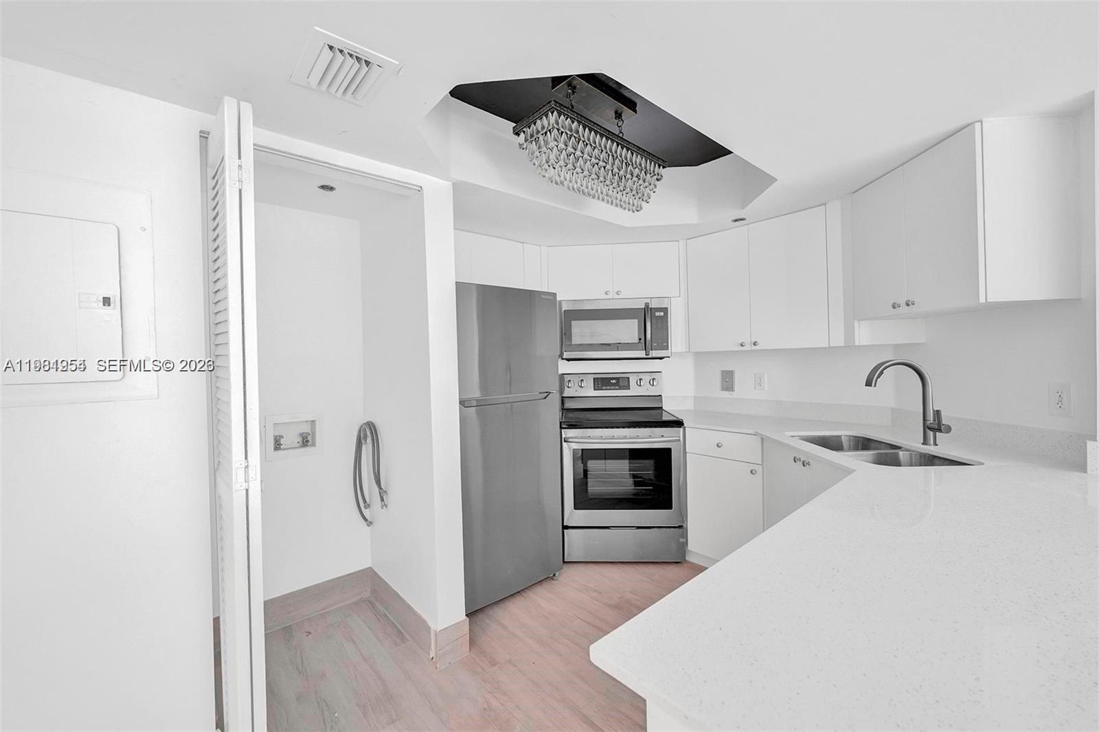 8911 Collins Avenue, Unit 703 Surfside, FL 33154 - Photo 5 of 24 a kitchen with stainless steel appliances a refrigerator sink and cabinets