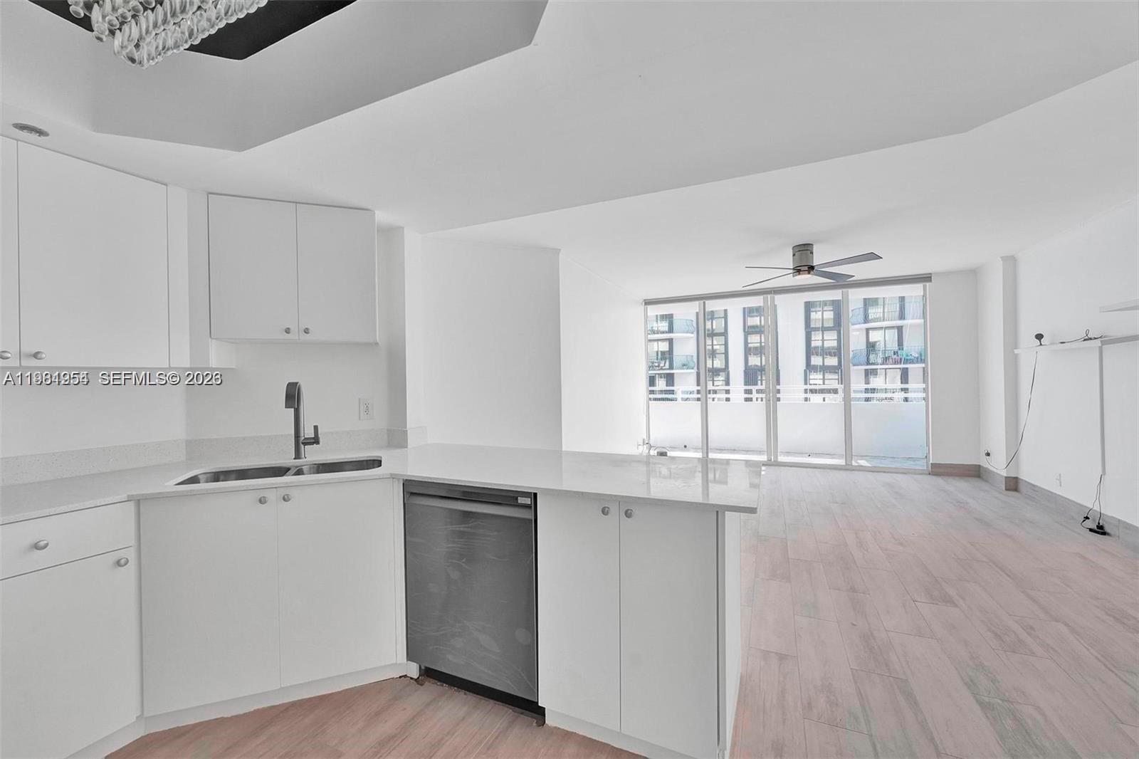 8911 Collins Avenue, Unit 703 Surfside, FL 33154 - Photo 6 of 24 a kitchen with a sink cabinets and window