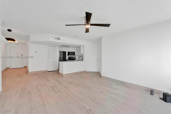 a view of empty room with wooden floor and window