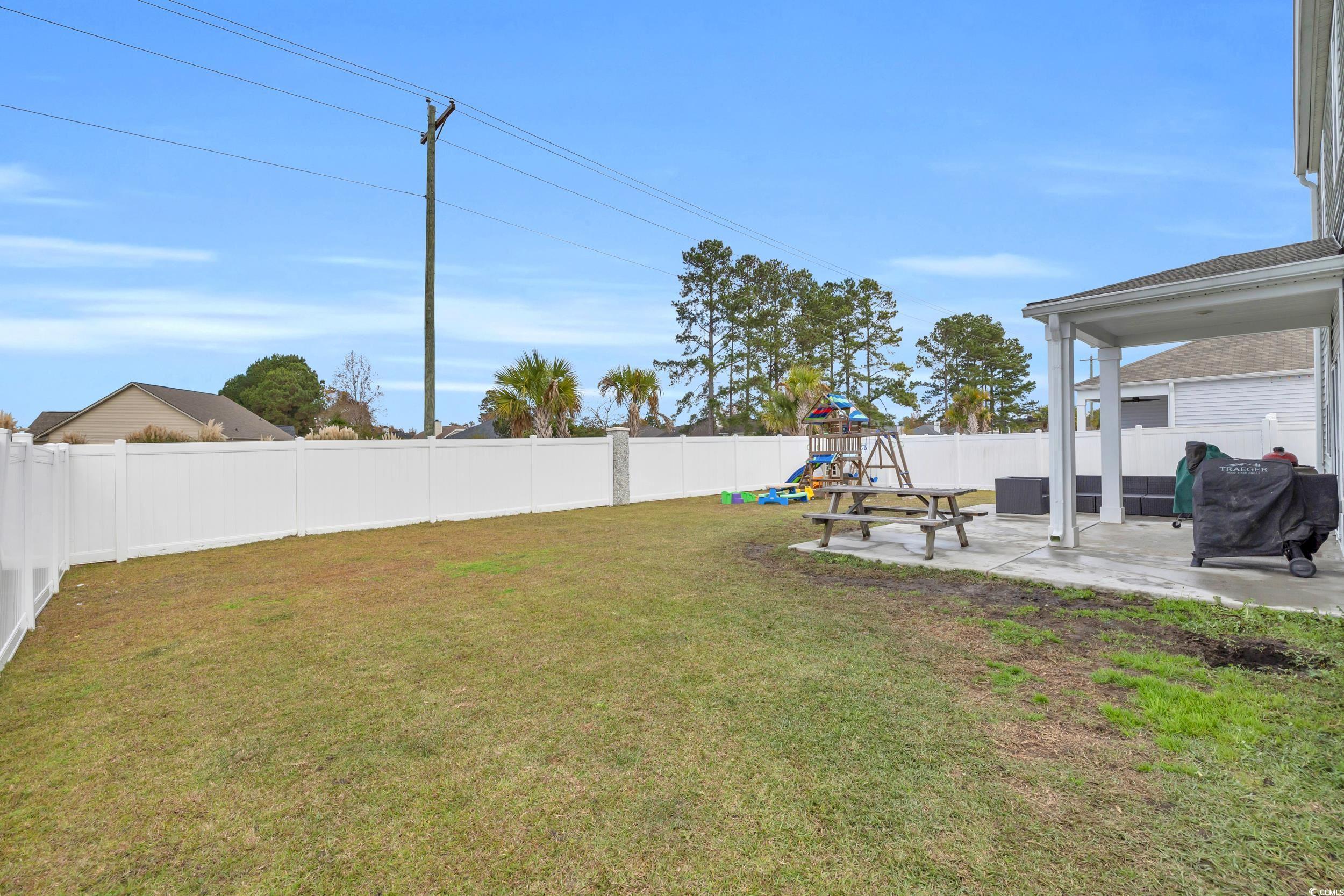 205 Black Pearl Way Myrtle Beach, SC 29588 - Photo 24 of 28 Fenced backyard featuring a playground and a patio