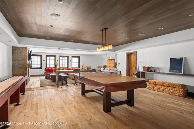 a living room with furniture a flat screen tv and a wooden floor