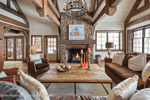 a living room with furniture a fireplace and a chandelier