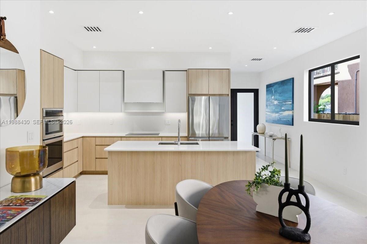 2925 Southwest 36th Avenue Miami, FL 33133 - Photo 17 of 59 a kitchen with stainless steel appliances a sink and a refrigerator