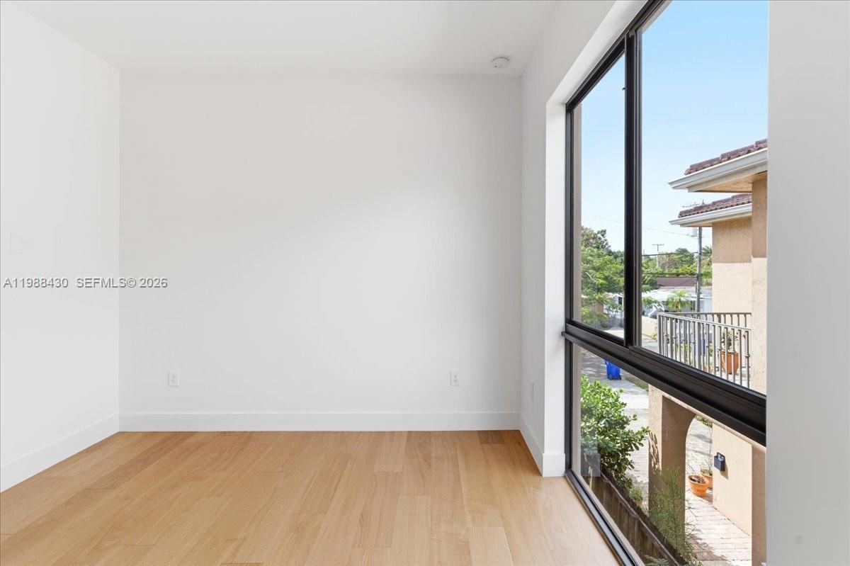 2925 Southwest 36th Avenue Miami, FL 33133 - Photo 31 of 59 an empty room with wooden floor and windows