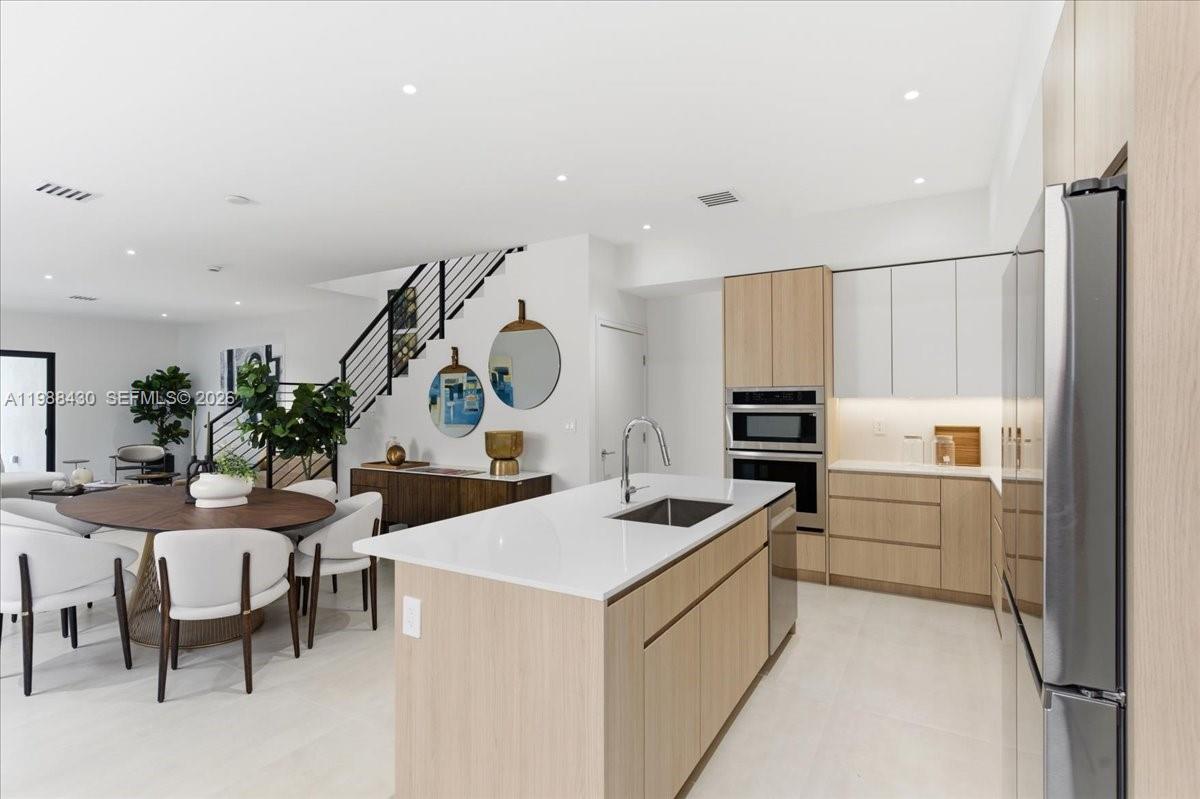 2925 Southwest 36th Avenue Miami, FL 33133 - Photo 4 of 59 a kitchen that has a lot of cabinets a sink and a stove in it