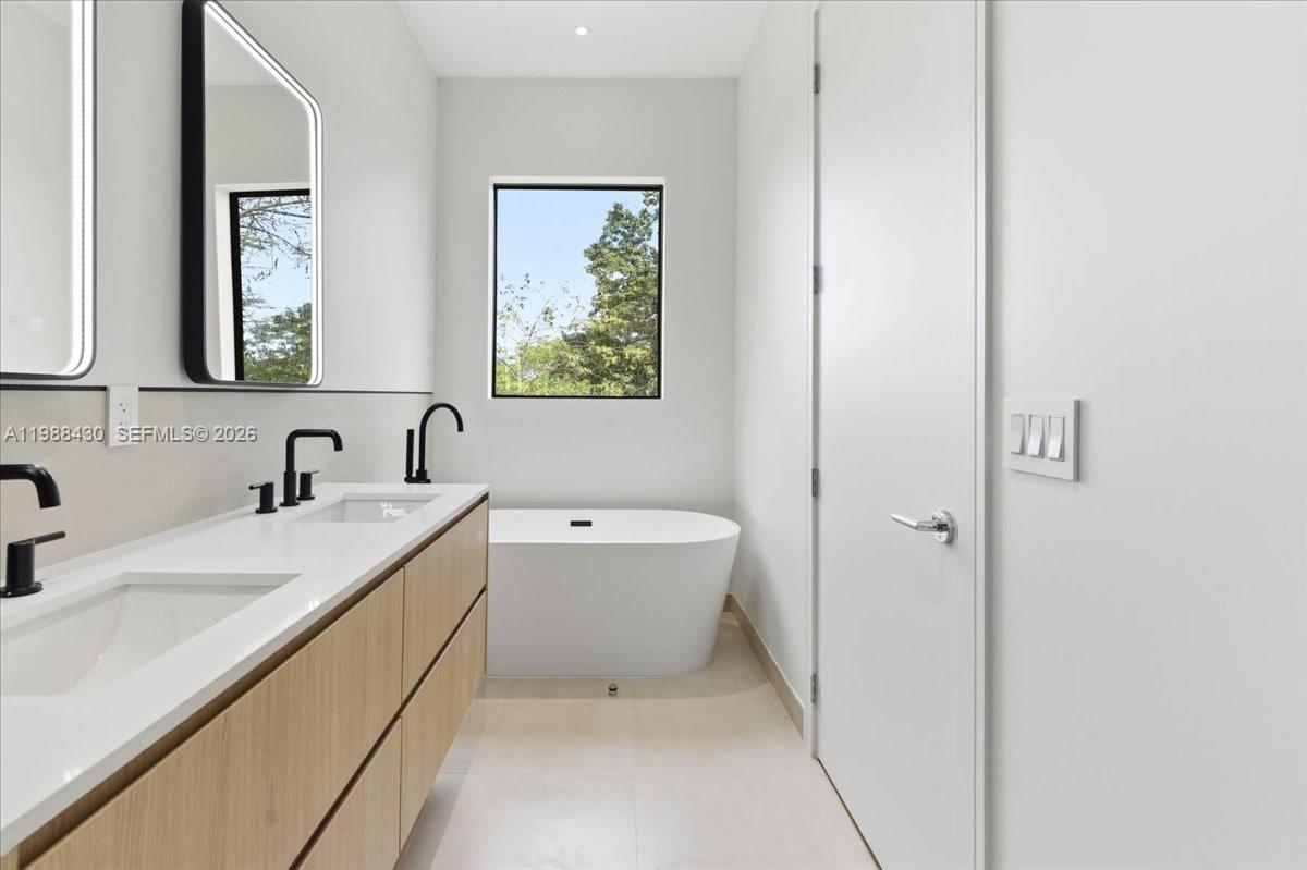 2925 Southwest 36th Avenue Miami, FL 33133 - Photo 50 of 59 a bathroom with a tub sink and mirror