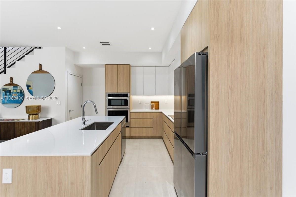 2925 Southwest 36th Avenue Miami, FL 33133 - Photo 5 of 59 a kitchen with stainless steel appliances granite countertop a sink and a refrigerator