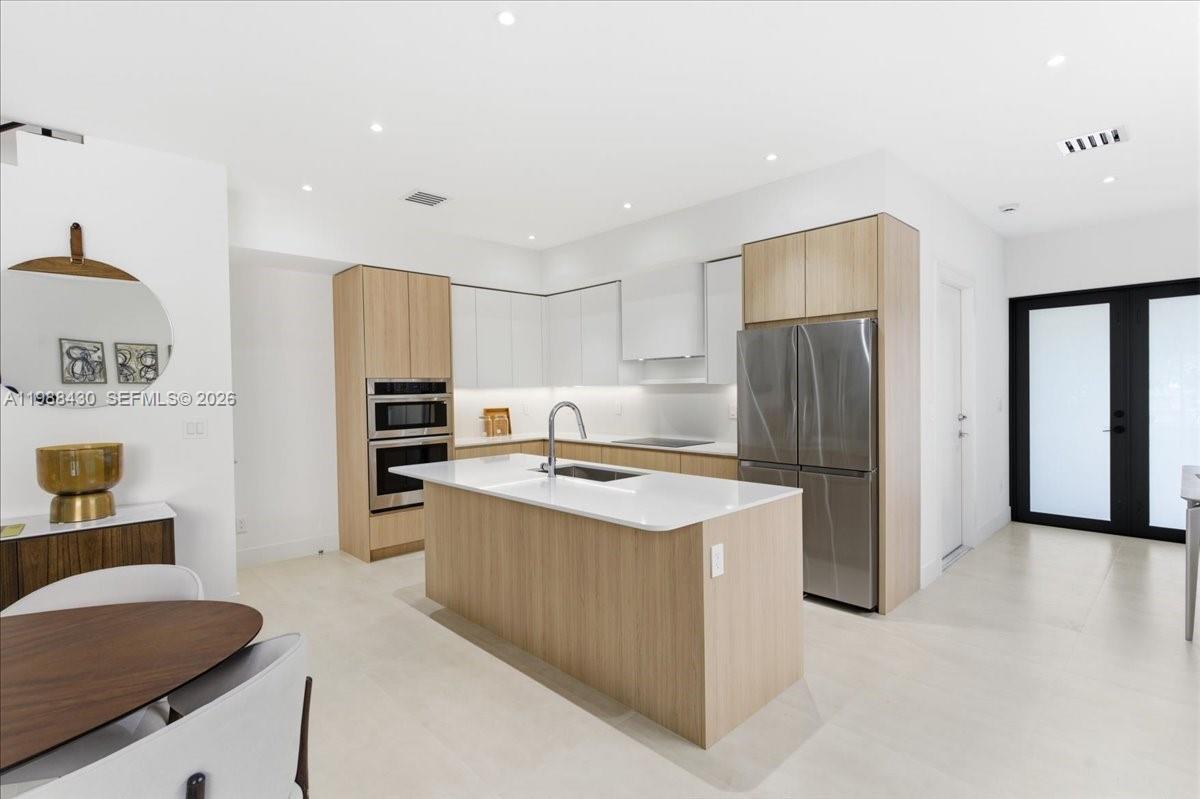 2925 Southwest 36th Avenue Miami, FL 33133 - Photo 8 of 59 a kitchen with stainless steel appliances granite countertop a refrigerator a stove and a sink