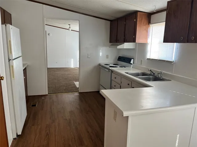 a kitchen with a sink a stove and a refrigerator
