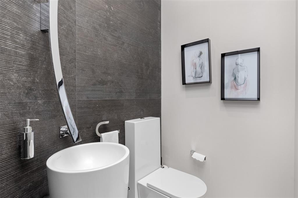 2140 North Ocean Boulevard, Unit V Fort Lauderdale, FL 33305 - Photo 17 of 63 a white toilet sitting next to a bathroom sink and a mirror