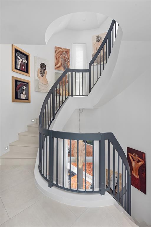 2140 North Ocean Boulevard, Unit V Fort Lauderdale, FL 33305 - Photo 38 of 63 a view of staircase with lots of frames on wall and wooden floor