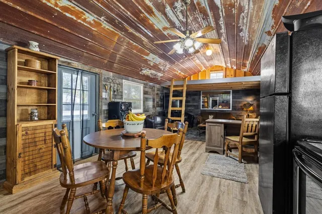 a view of a patio with table and chairs with wooden floor and fence