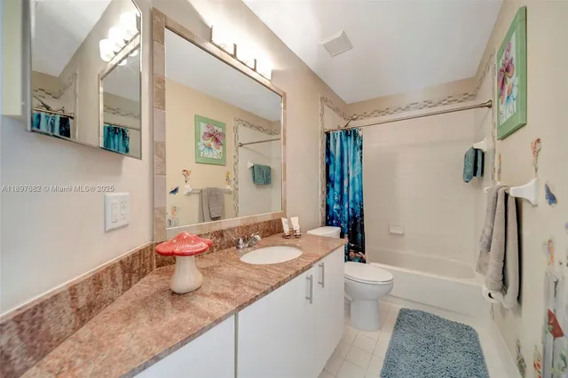 a bedroom with a large bed and a flat tv screen on the dresser