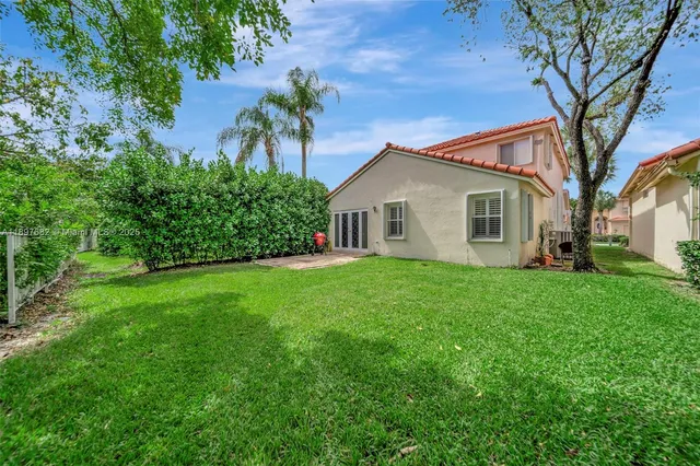 an aerial view of residential houses with outdoor space and trees