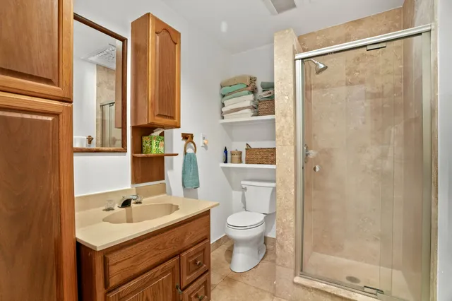 a bathroom with a sink toilet a mirror and shower
