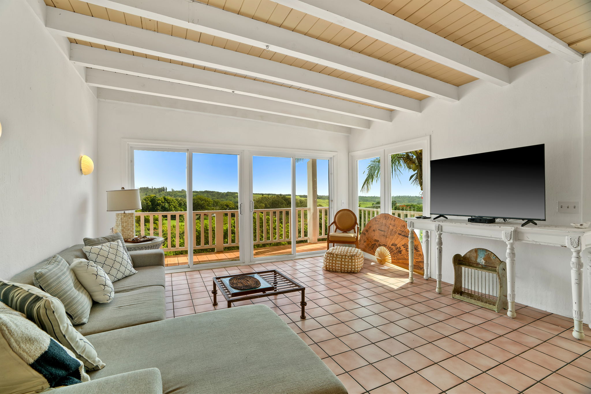 5366 Kumole Street Kapaa, HI 96746 - Photo 17 of 30 a living room with furniture a flat screen tv and a floor to ceiling window