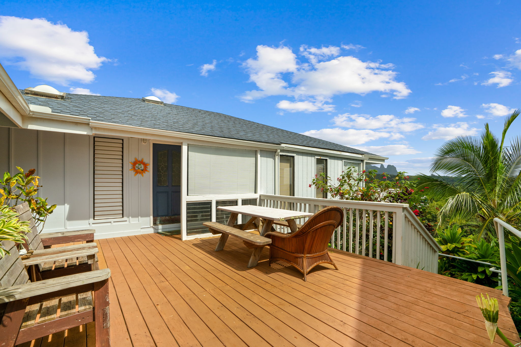 5366 Kumole Street Kapaa, HI 96746 - Photo 2 of 30 a view of a patio with dining table and chairs with wooden floor and fence
