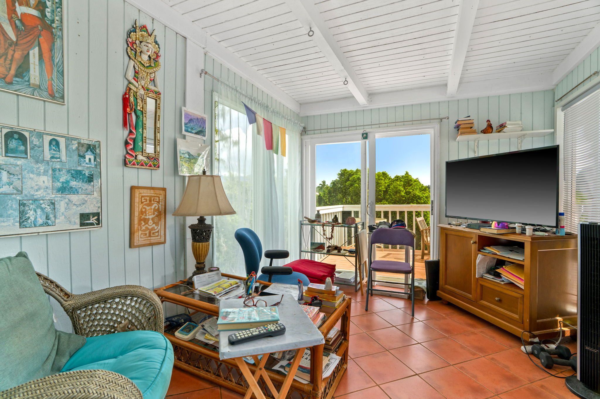5366 Kumole Street Kapaa, HI 96746 - Photo 25 of 30 a living room with furniture a flat screen tv and a floor to ceiling window