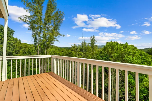 a balcony with wooden floor and fence