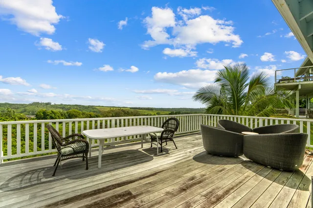a view of a roof deck with table and chairs with wooden floor and fence