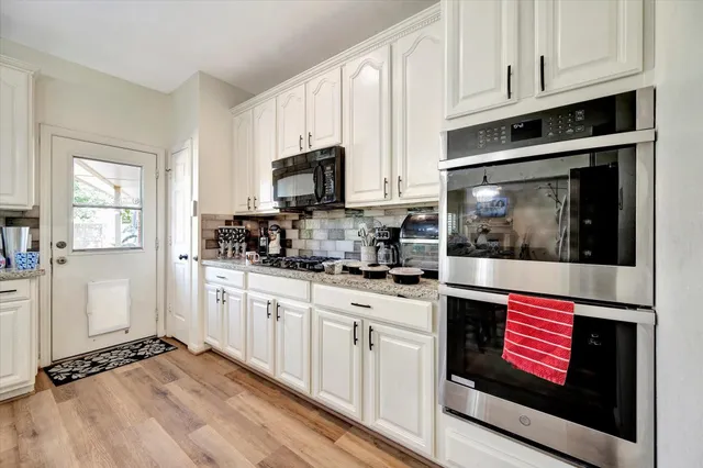a kitchen with cabinets appliances and a window