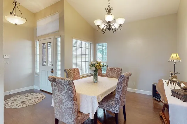 a view of a dining room with furniture wooden floor and chandelier