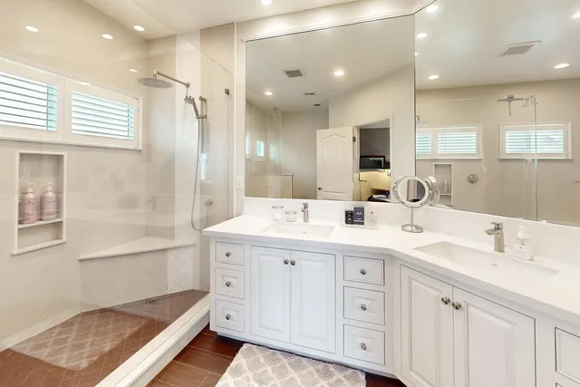 a bathroom with a tub shower vanity and a sink