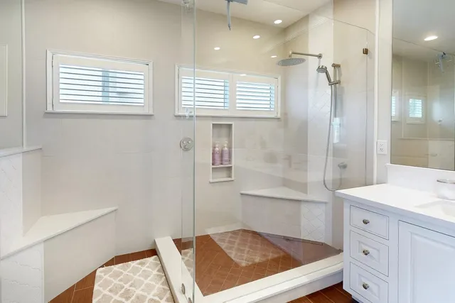a spacious bathroom with a double vanity sink a mirror and a