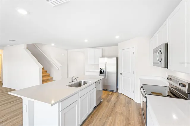 a kitchen with a sink appliances and cabinets
