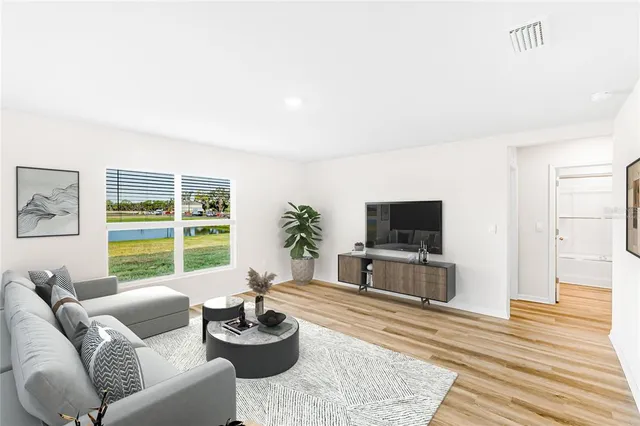 a living room with furniture a flat screen tv and a large window