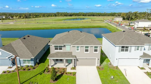 an aerial view of a house with a big yard and large trees