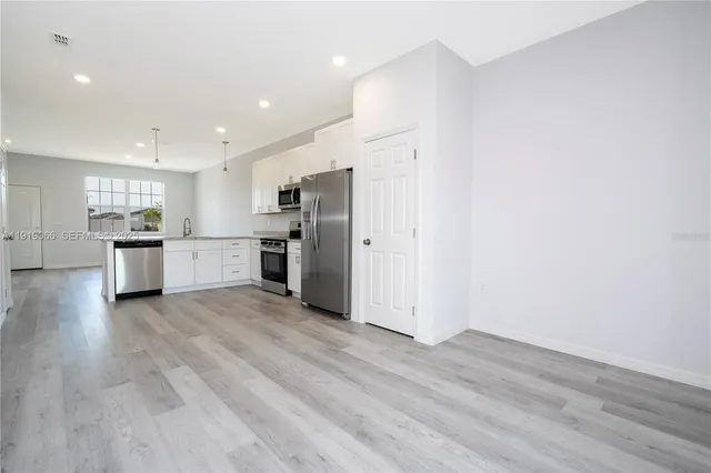 a view of kitchen with refrigerator stove microwave and cabinets