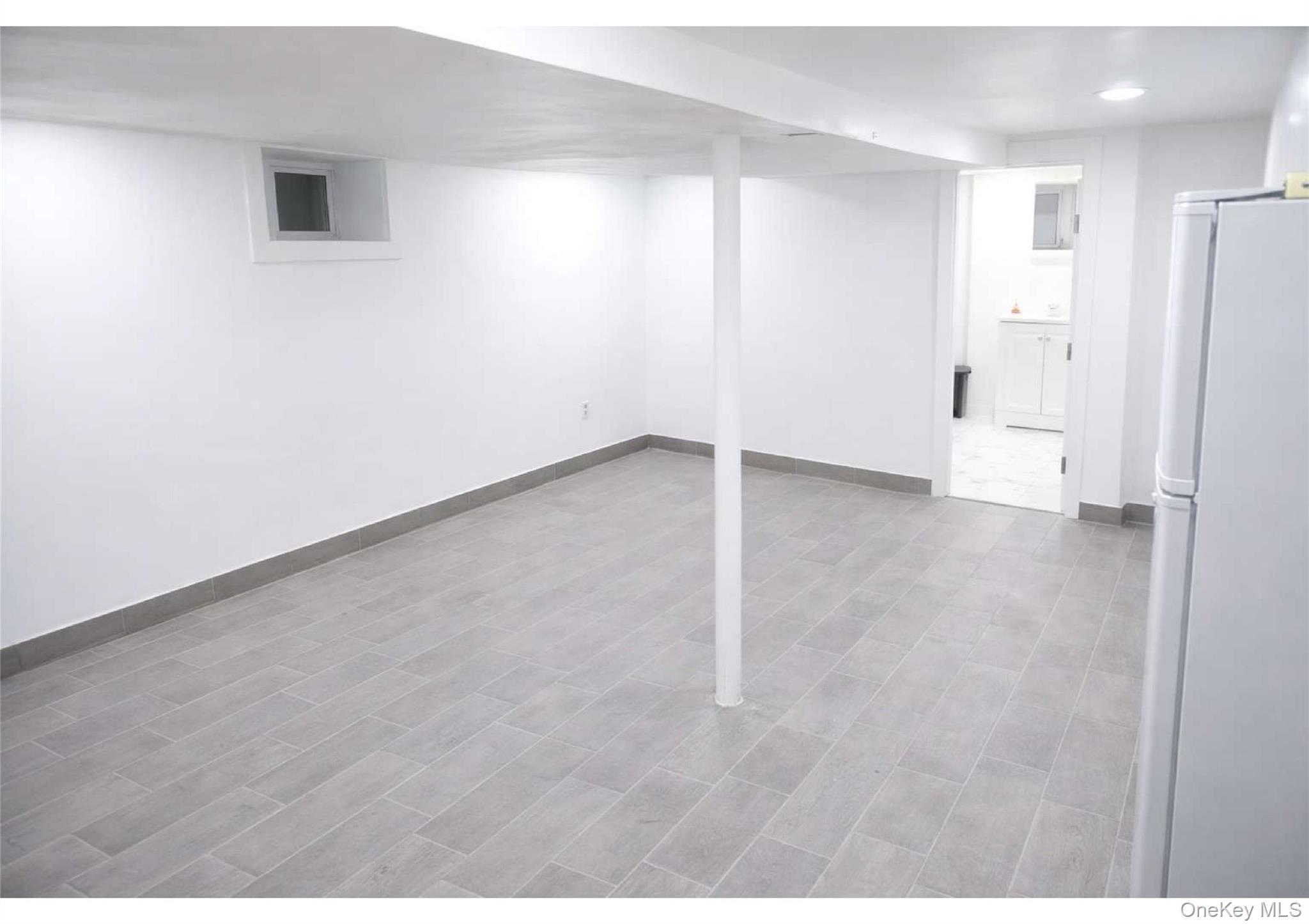 86-19 79th Street Queens, NY 11421 - Photo 12 of 19 a view of an empty room and a window