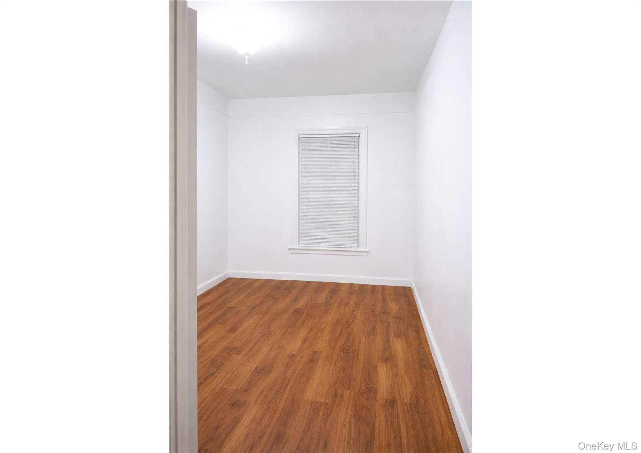 86-19 79th Street Queens, NY 11421 - Photo 13 of 19 a view of a room with wooden floor