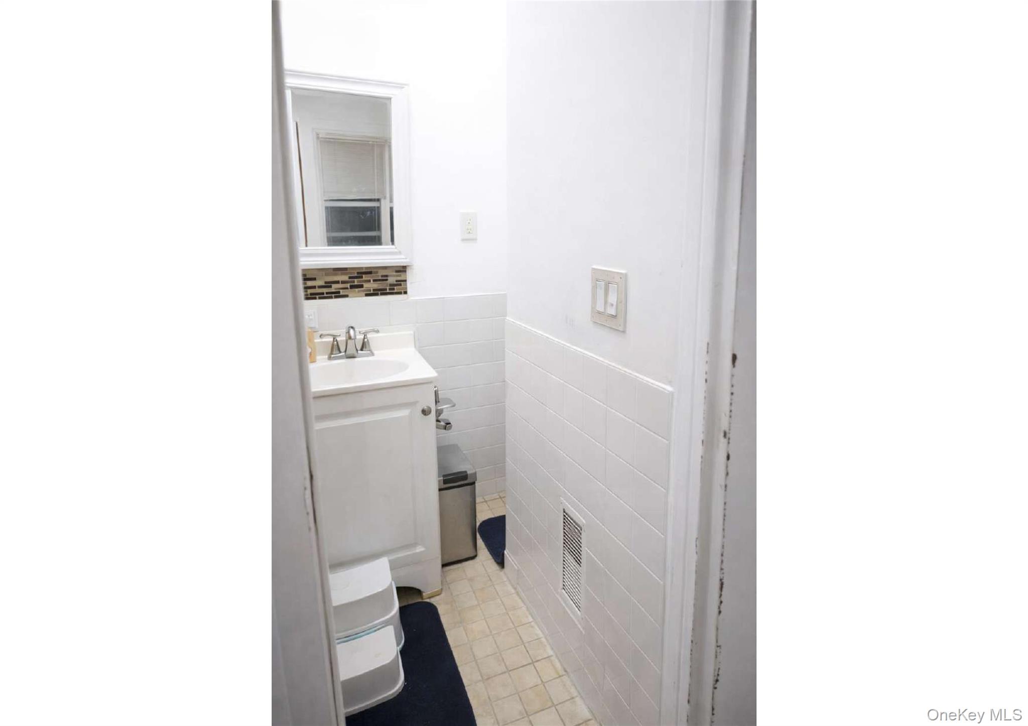 86-19 79th Street Queens, NY 11421 - Photo 6 of 19 a bathroom with a sink toilet and mirror