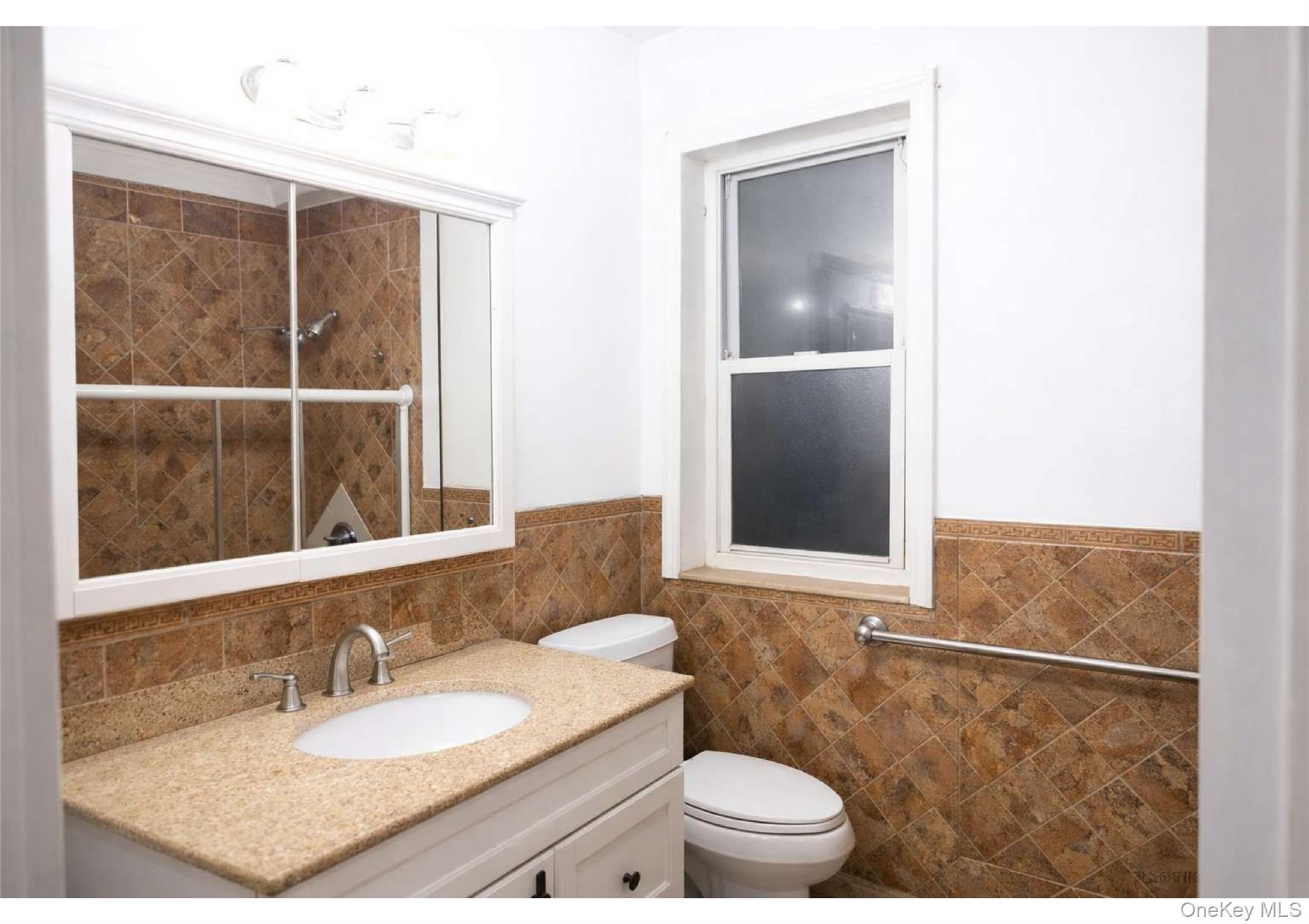86-19 79th Street Queens, NY 11421 - Photo 8 of 19 a bathroom with a granite countertop sink and a mirror