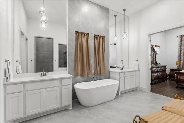 a bathroom with a double vanity sink a mirror a bathtub and shower